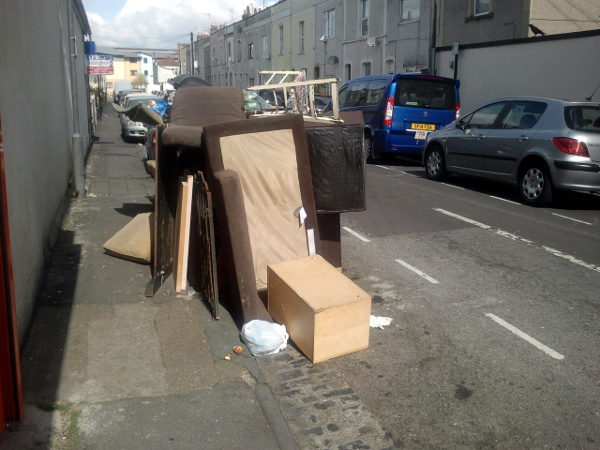 communal bin in Milsom Street buried under a pile of fly-tipped furniture