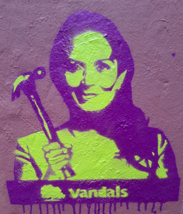 stencil art of Priti Patel holding hammer with the word vandals and the Conservative Party oak tree logo beneath