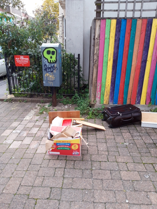 Cardboard and other items in front of no fly-tipping sign