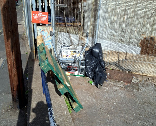 No fly-tipping sign in Ducie Road car park above fly-tipped waste