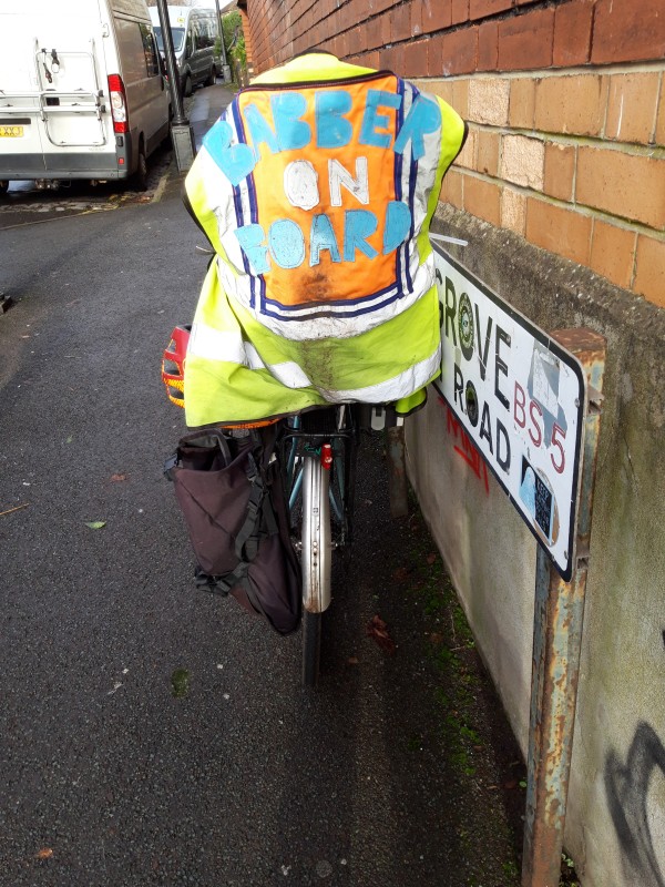 Rear view of bicycle with child seat covered with fluorescent tabard bearing wording Babber on Board