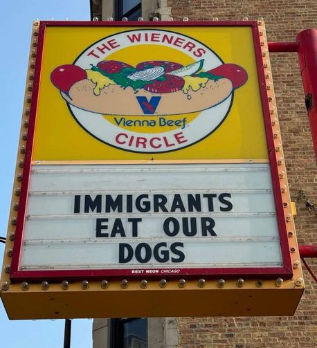 Illuminated sign for The Wieners Circle withe the addendum Immigrants eat our dogs 