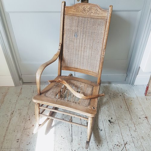 before shot - worn out rocking chair with a broken arm and broken cane seat
