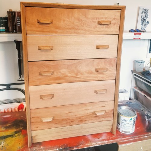 After shot of chest of drawers with its veneer removed, sanded and refinished